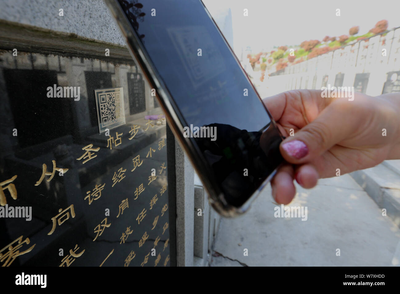 Une section locale utilise son téléphone portable pour scanner le code QR sur une pierre tombale d'obtenir des informations détaillées au 9, Boulevard Maréchal Joffre Memorial Park dans la ville de Xiangyang, le centre de la Chine Banque D'Images
