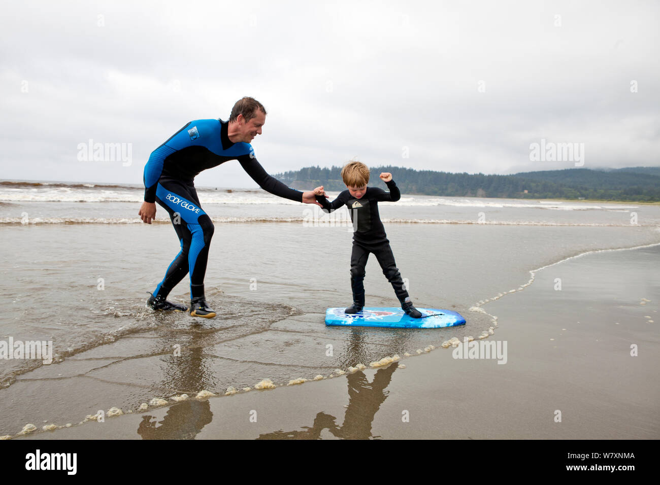 Nate Harrison d'enseigner son fils Gabriel comment surfer, Hobuck Beach, réserve Makah, Washington, USA, août 2014. Parution du modèle. Parution du modèle. Banque D'Images