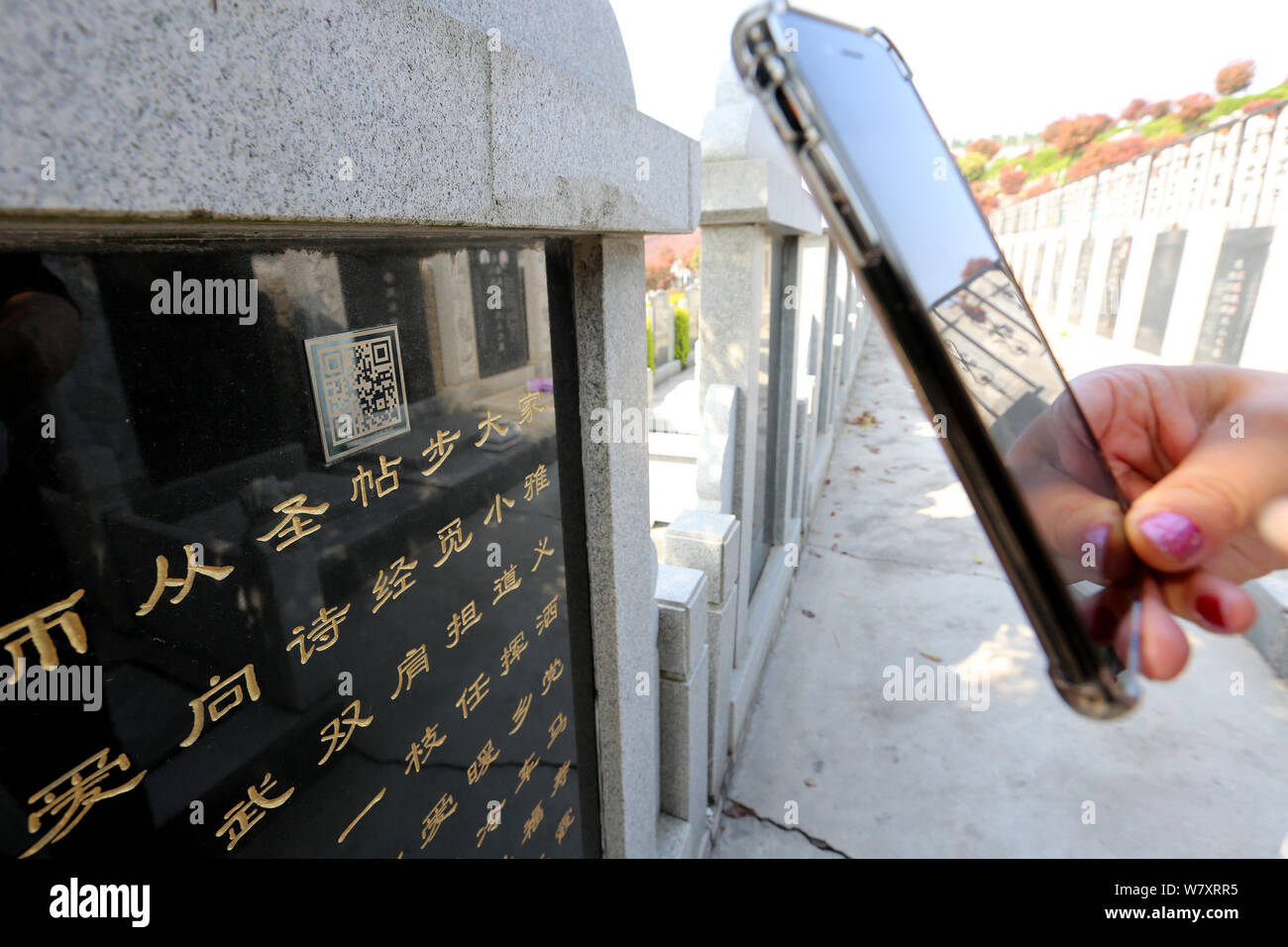 Une section locale utilise son téléphone portable pour scanner le code QR sur une pierre tombale d'obtenir des informations détaillées au 9, Boulevard Maréchal Joffre Memorial Park dans la ville de Xiangyang, le centre de la Chine Banque D'Images