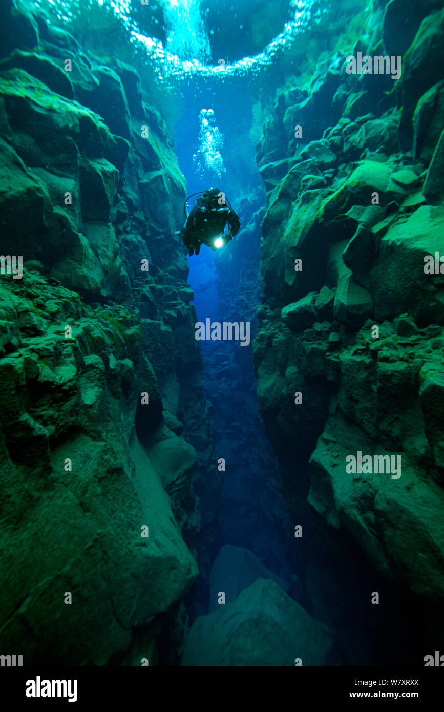 Diver explorer le Canyon de Silfra S.p.a. - problème profond rempli d'eau douce dans la vallée du Rift, entre les plaques tectoniques eurasienne et américaine, au Parc National de Thingvellir, Islande. Juin 2014. Banque D'Images