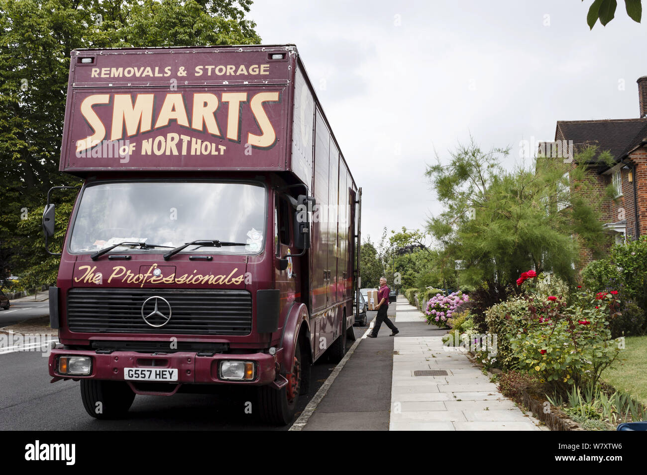 Londres, Royaume-Uni - 21 juillet, 2014. Un emballeur professionnel porte un fort à l'arrière d'un grand camion dépose sur une route de banlieue à Londres, Royaume-Uni Banque D'Images