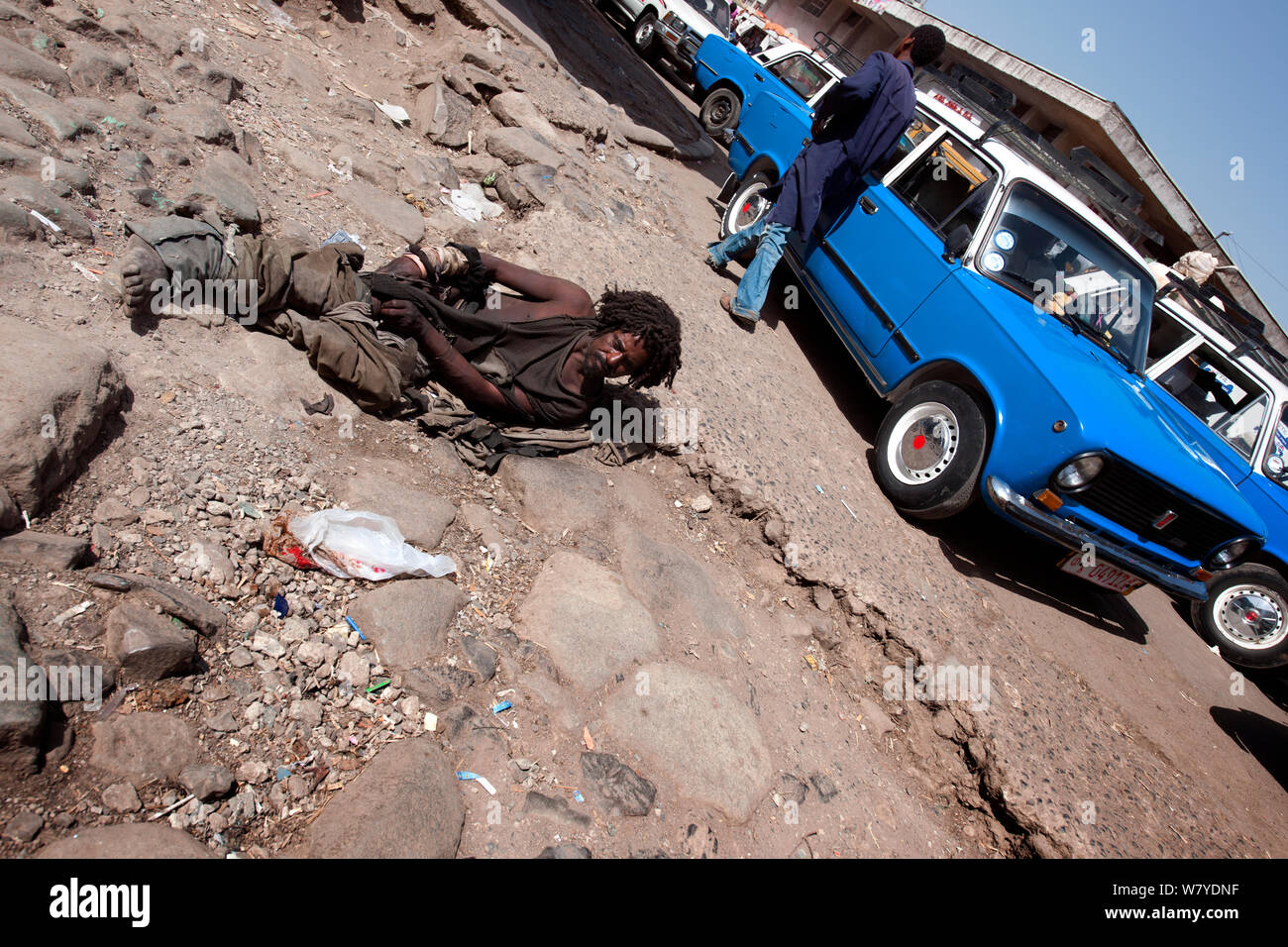 Mendiant sans-abri se trouve sur le sol près d'une station de taxi à Mercato, Addis Ababa, Ethiopie. Février 2009 Banque D'Images
