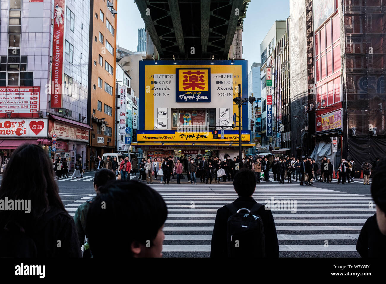 Les piétons attendent pour traverser une rue dans le quartier d'Akihabara à Tokyo, Japon Banque D'Images
