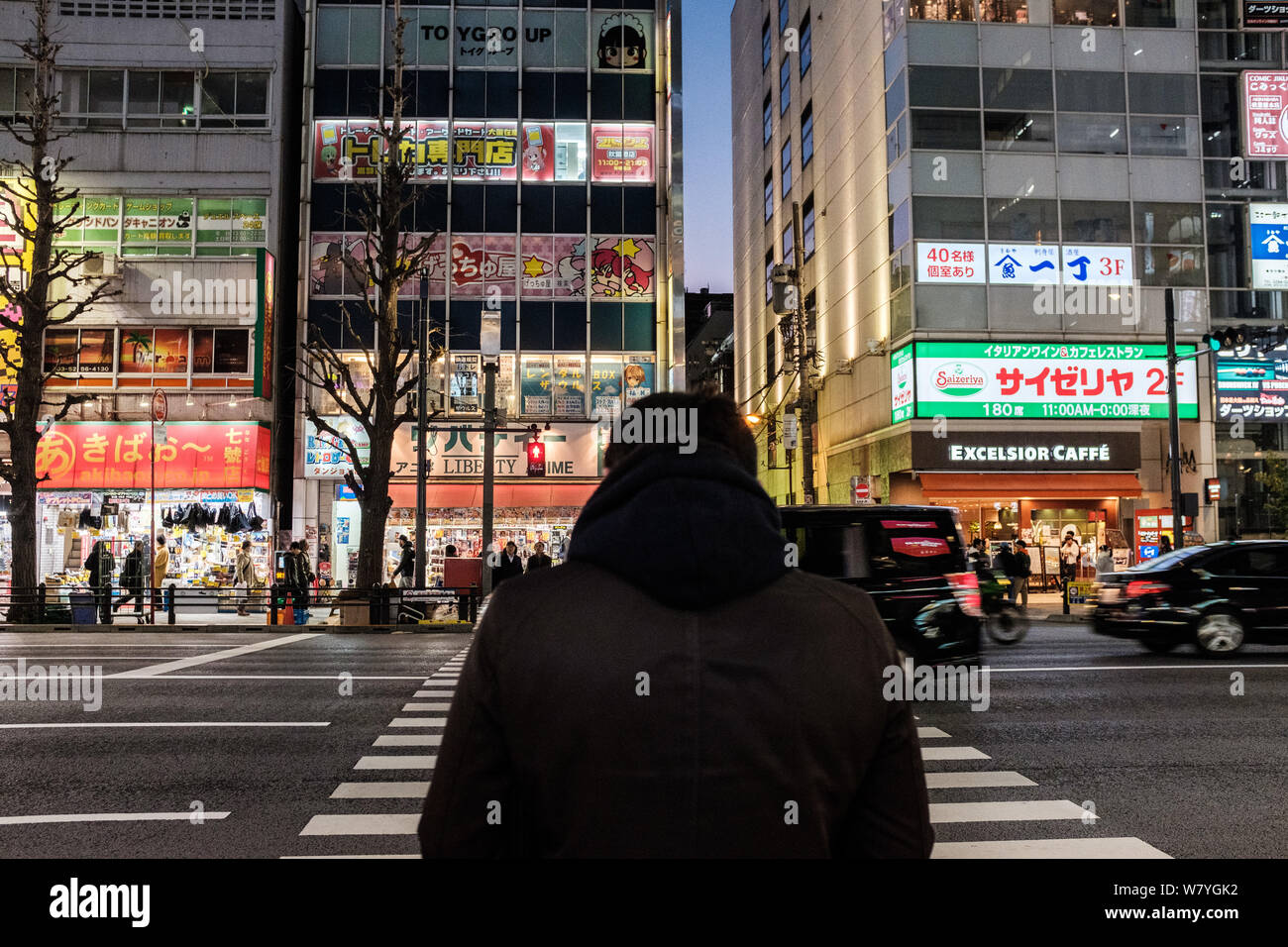D'attente pour les piétons de traverser une rue dans le quartier d'Akihabara à Tokyo, Japon Banque D'Images