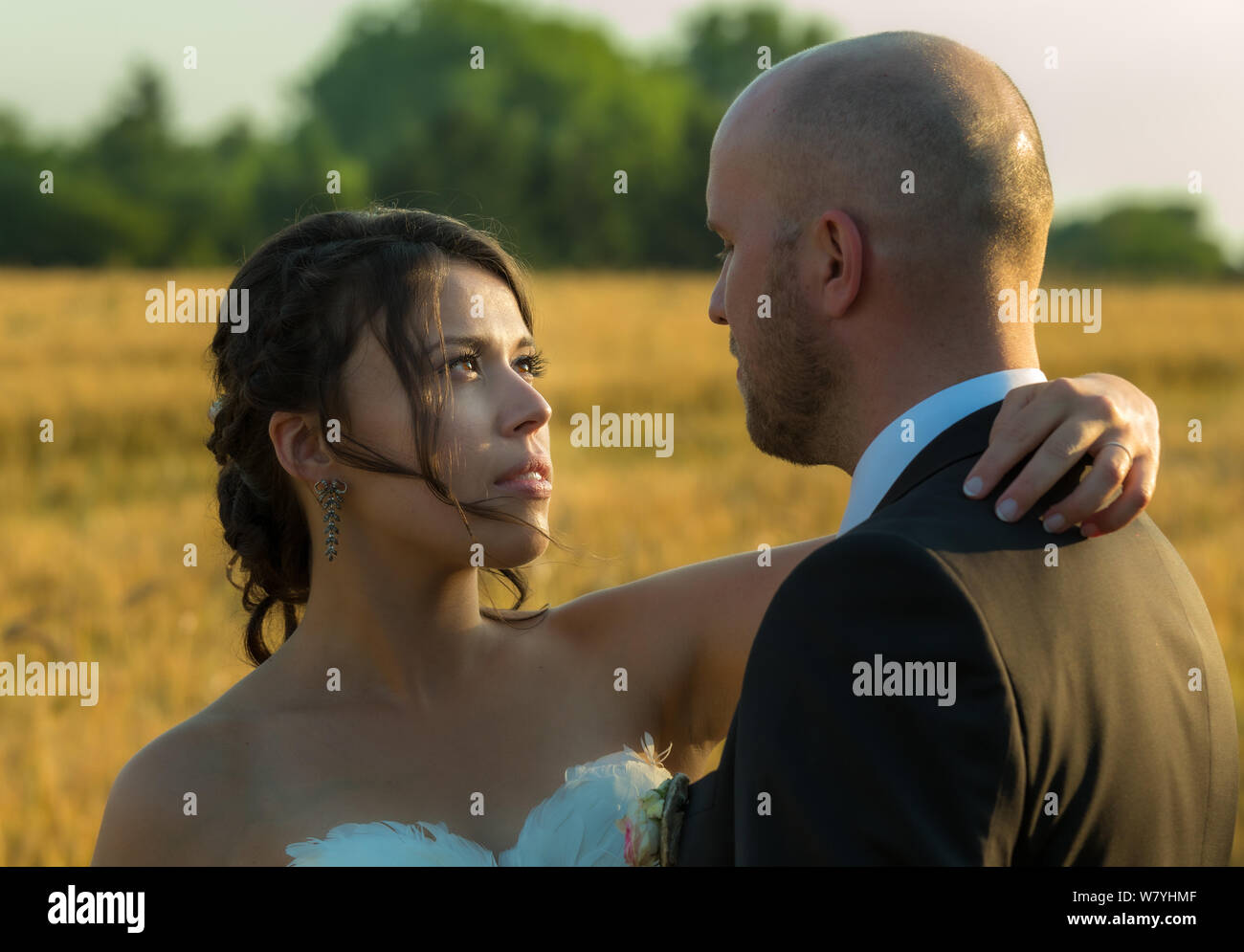 Couple romantique dans la journée du mariage, il a l'air d'aimer les yeux en voyant le coucher du soleil Banque D'Images