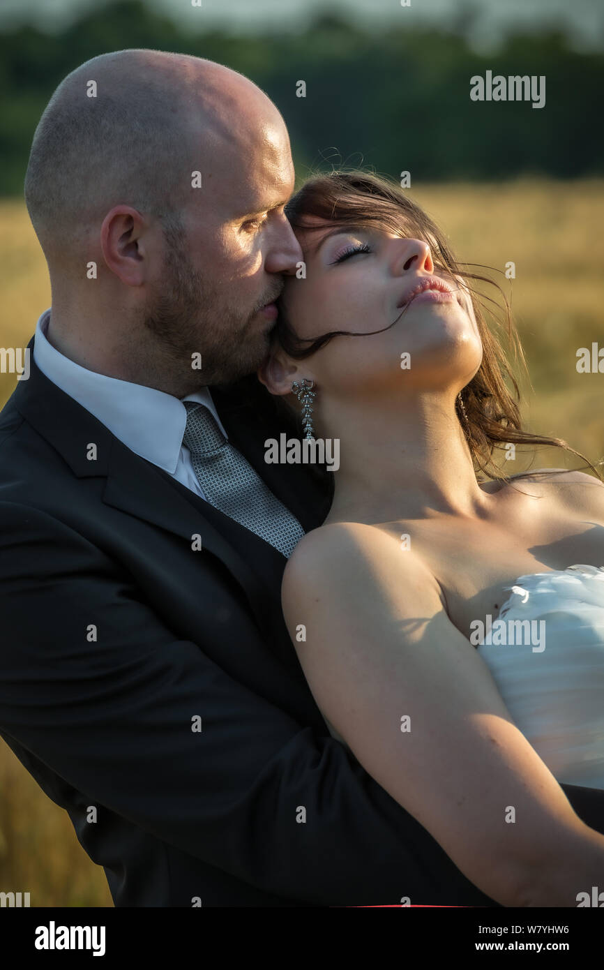 Couple romantique dans la journée du mariage pour le coucher du soleil face à la lumière Banque D'Images