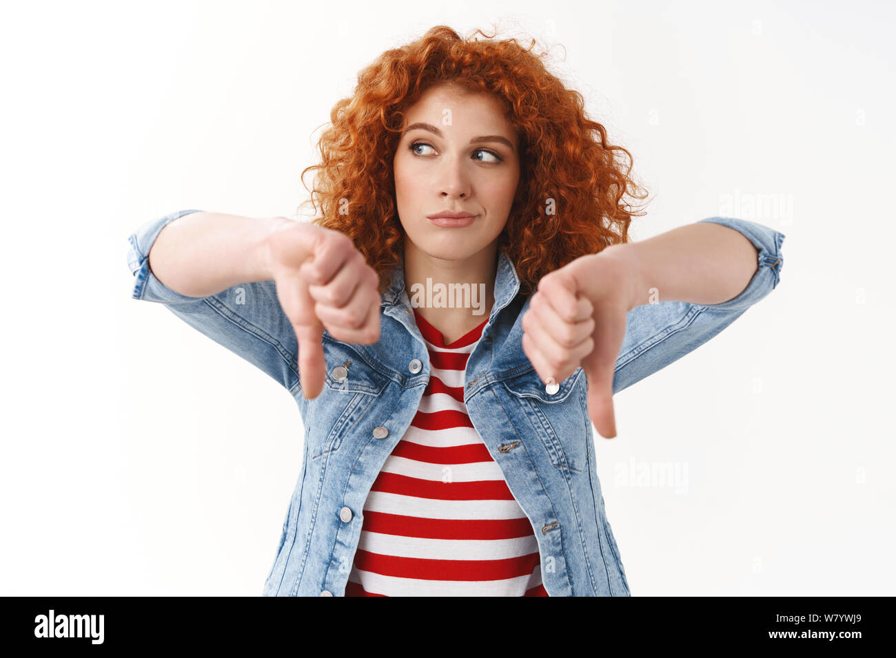 Fille déçue mauvais film. Réticents rousse femme aux cheveux bouclés le regard ennuyé show Thumbs down déplut à exprimer sa désapprobation n'aiment pas penser ga Banque D'Images