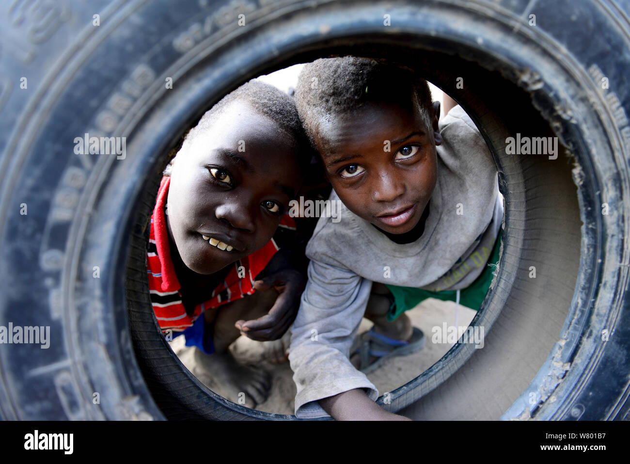 Enfants jouant avec le pneu d'une roue. Village d'Ari. Vallée de l'Omo. L'Éthiopie, Novembre 2014 Banque D'Images