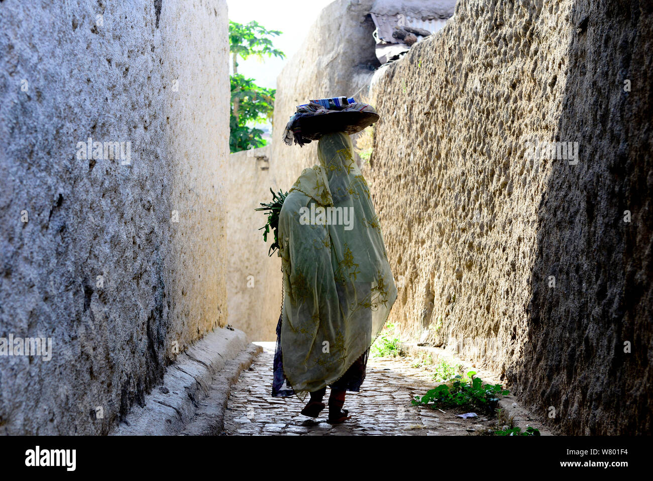 Femme musulmane marcher dans les rues étroites, Harar, une importante ville sainte dans la foi islamique, UNESCO World Heritage Site. L'Éthiopie, Novembre 2014 Banque D'Images