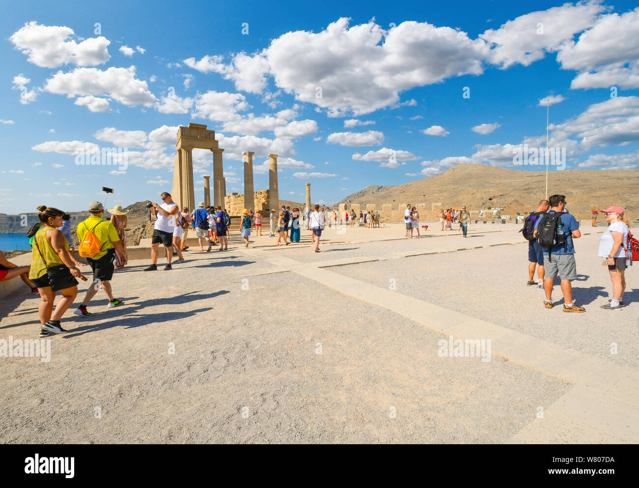 Les touristes profiter de la fin de l'après-midi vue sur la mer Méditerranée depuis les anciennes ruines de l'Acropole de Lindos, sur l'île de Rhodes, Grèce Banque D'Images