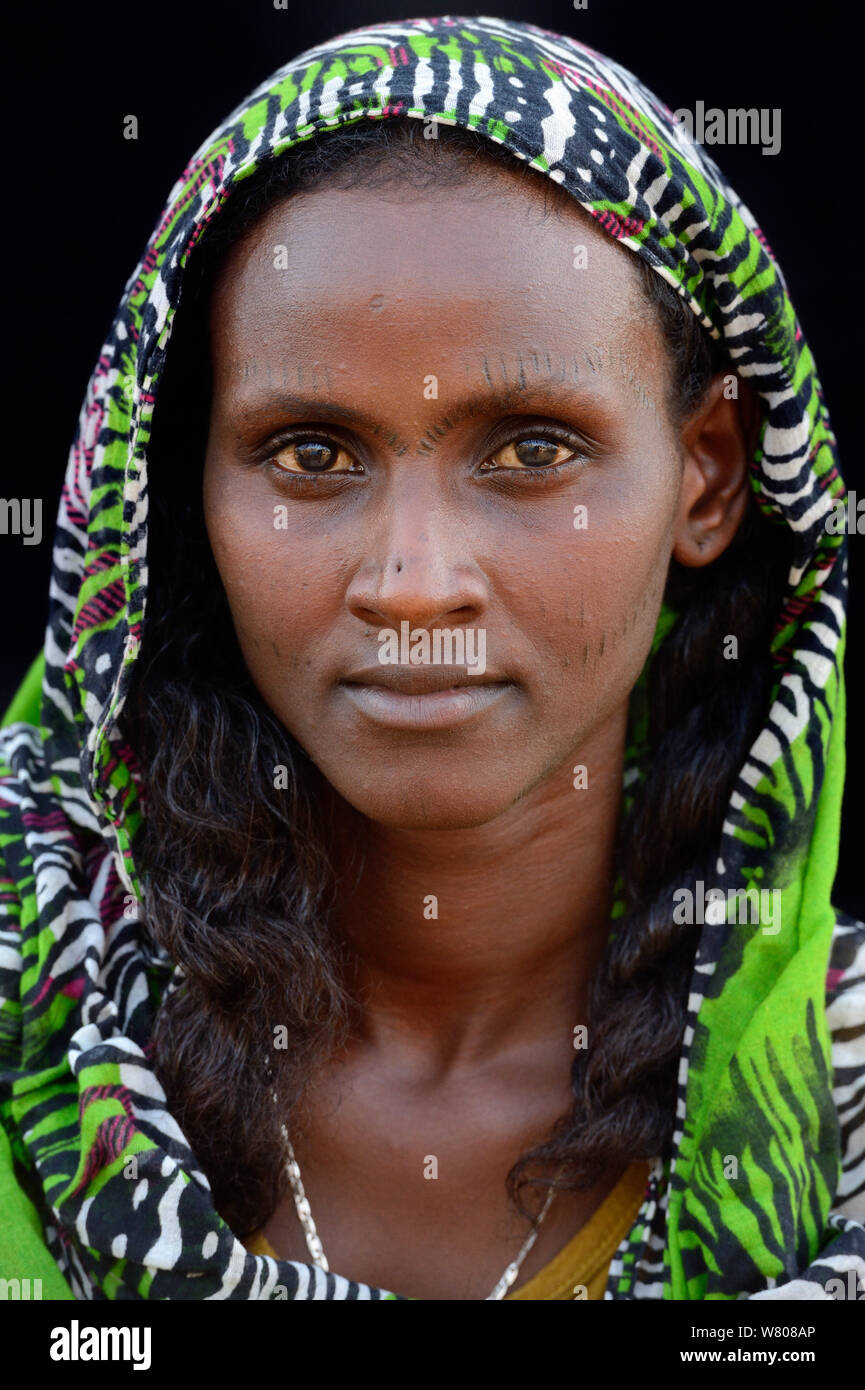 Tête portrait de femme de la tribu Afar avec tatouages faciaux / peau scarifications et porter un foulard, Ahmed Ela village, dépression Danakil, région Afar, en Ethiopie, en mars 2015. Banque D'Images