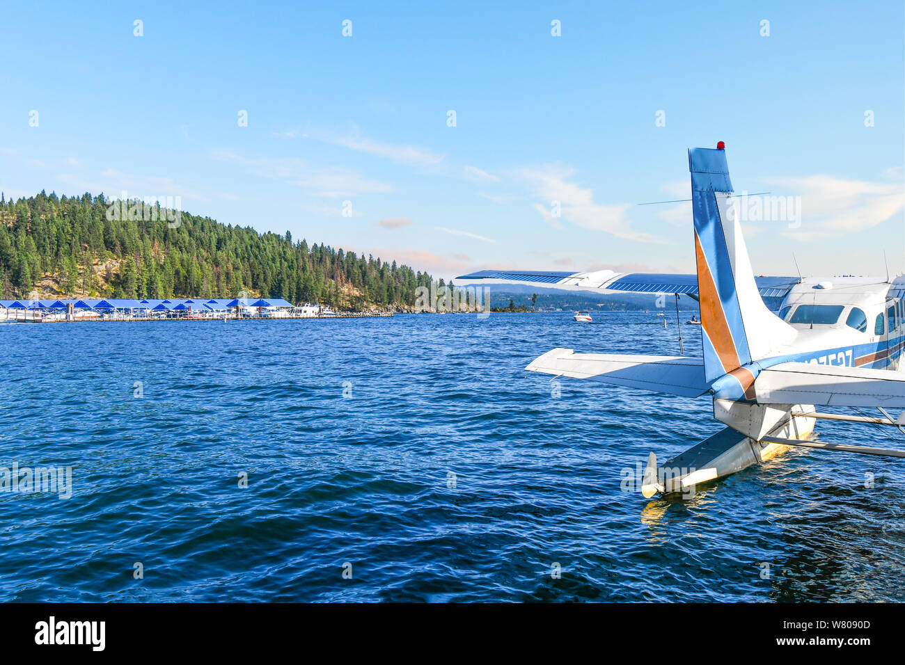 Un hydravion se trouve dans l'eau, dans une baie près d'une marina et d'un complexe au lac coeur d'Alene, Idaho, avec Tubbs Hill en arrière-plan. Banque D'Images