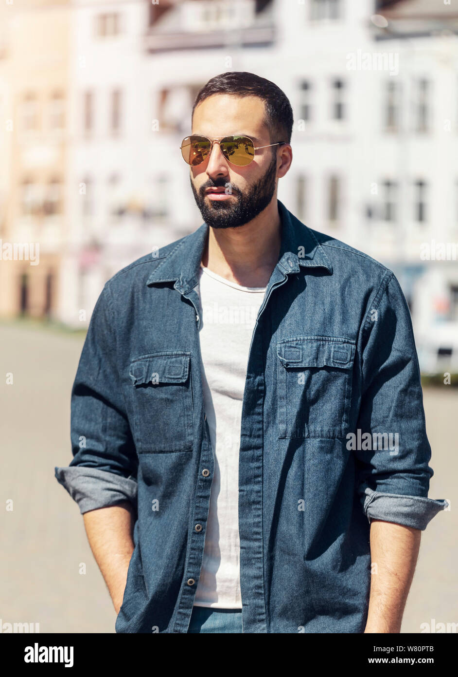 Succès permanent antrepreneur confiant devant un bulding en jeans shirt Banque D'Images