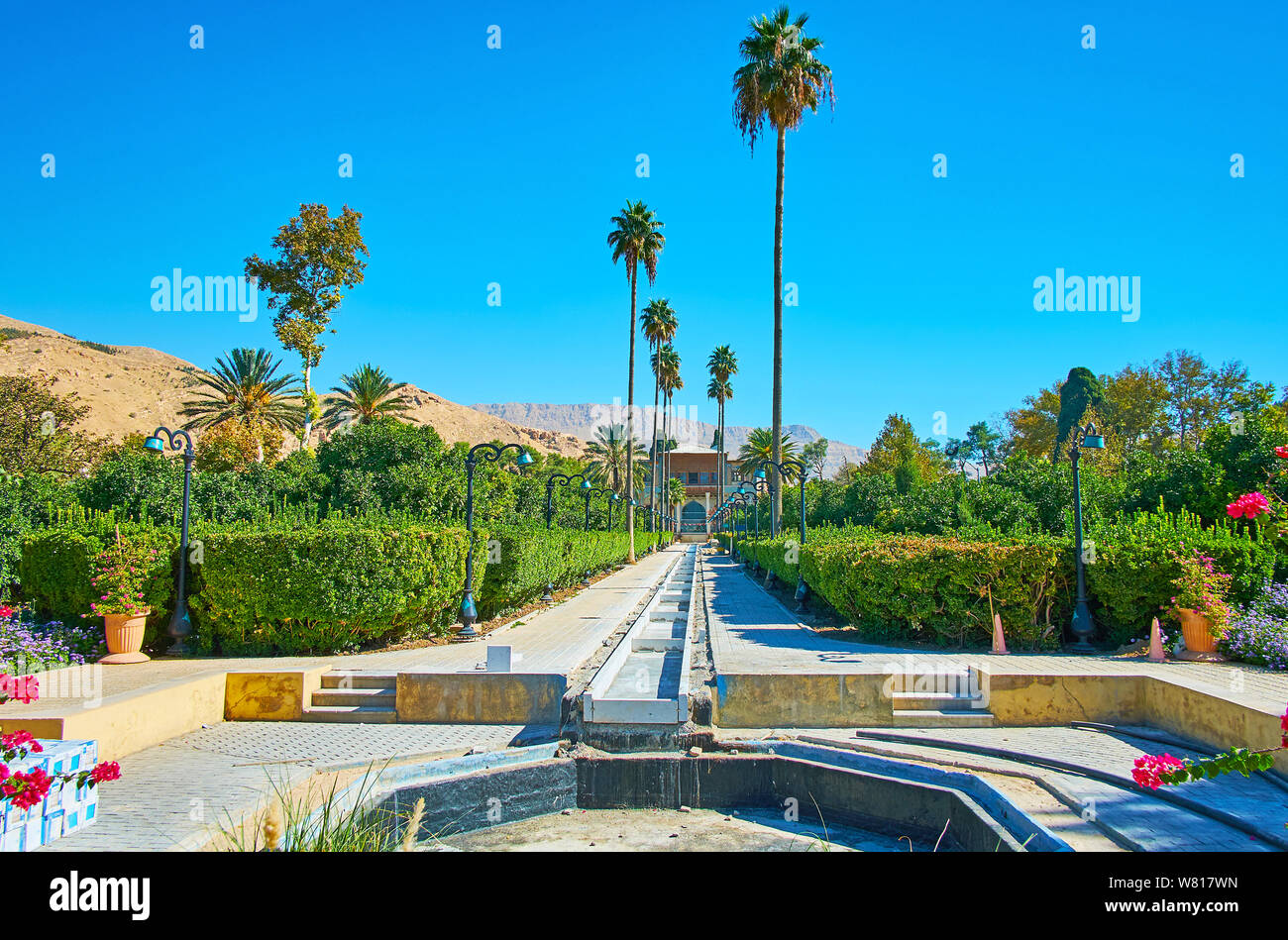 Profitez du jardin Delgosha pittoresque avec de grands palmiers, plantes topiaires et ombragé alley, situé au pied de la roche de dessert, Shiraz, Iran Banque D'Images