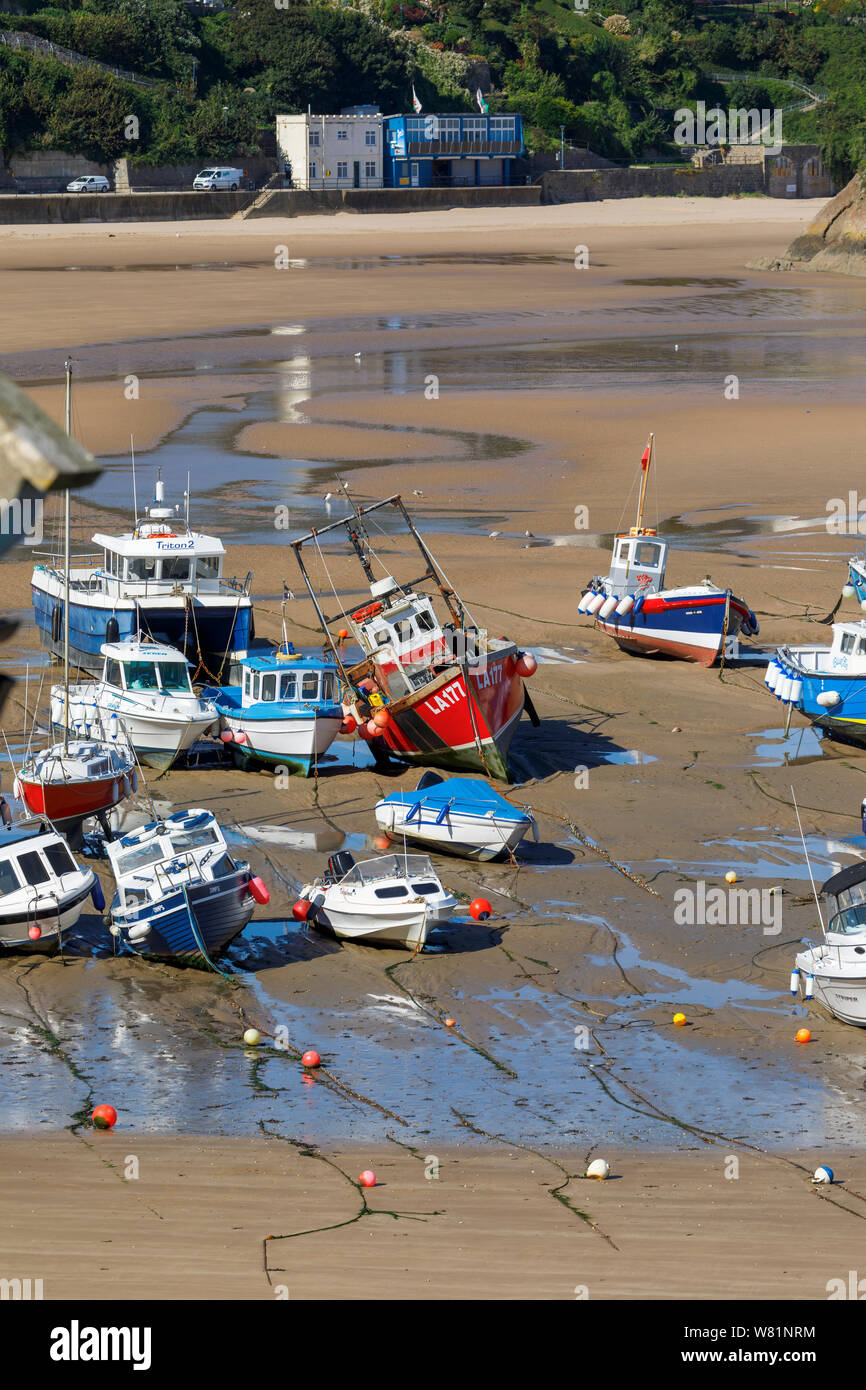 Les bateaux de pêche s'échouer à marée basse dans le port de Tenby, une ville balnéaire fortifiée dans la région de Pembrokeshire, Pays de Galles du sud sur la côte ouest de la baie de Carmarthen Banque D'Images
