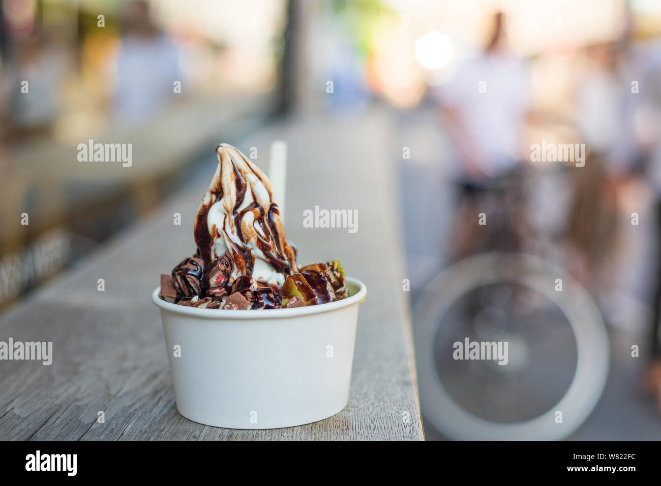 Servir avec du yogourt glacé blanc avec garniture de fruits et de chocolat blanc, coupe papier sur le comptoir en bois table sur rue. Banque D'Images