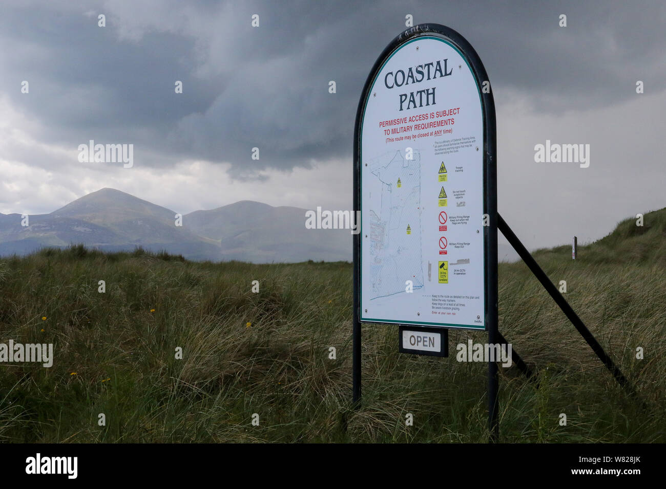 Panneau d'entrée de la voie à travers des terres MOD permissive à Ballykinler par temps humide en été avec un ciel gris sur la Mourne Mountains dans la distance. Banque D'Images