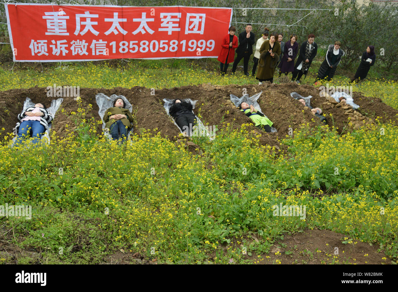 Les femmes chinoises se trouvent dans des "tombes" dans la loi de 'cimetière' méditation au cours d'un rituel peu commun pour aider les divorcés à faire face à leur rupture du mariage i Banque D'Images