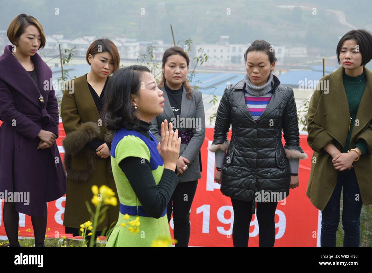 Une femme chinoise partage les sentiments de 'cimetière' méditation avec les autres après avoir couché dans un tombeau 'terre' au cours d'un rituel peu commun pour aider les divorcés faire face Banque D'Images