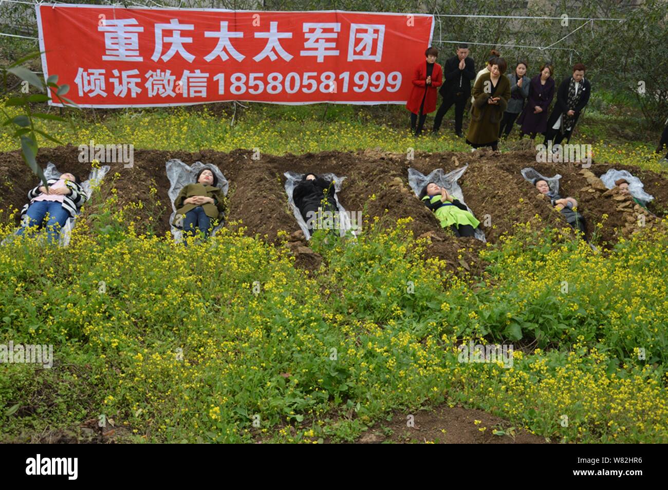 Les femmes chinoises se trouvent dans des "tombes" dans la loi de 'cimetière' méditation au cours d'un rituel peu commun pour aider les divorcés à faire face à leur rupture du mariage i Banque D'Images