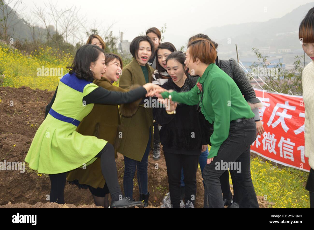 Les femmes chinoises s'applaudir après être resté dans des "tombes" au cours d'un rituel peu commun pour aider les divorcés à faire face à leur rupture du mariage dans l'out Banque D'Images