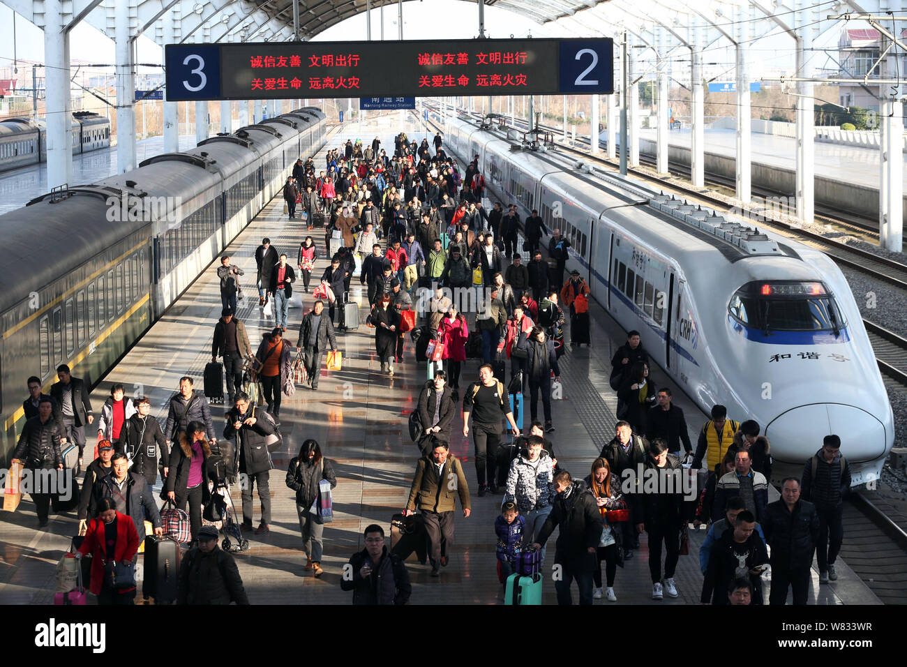Les passagers chinois à pied vers la sortie à la gare ferroviaire de Xi'an qu'ils sont sur leur chemin de retour à la maison pour la prochaine fête du printemps ou le Chi Banque D'Images