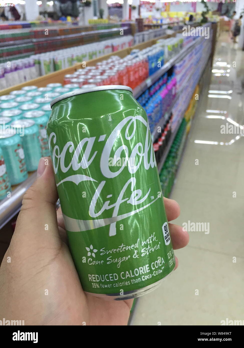 --FILE--un client des magasins pour une canette de Coke de Coca-Cola dans un supermarché à Shanghai, Chine, le 24 juillet 2016. Le conglomérat de Hong Kong Swire Pacific Ltd. Banque D'Images