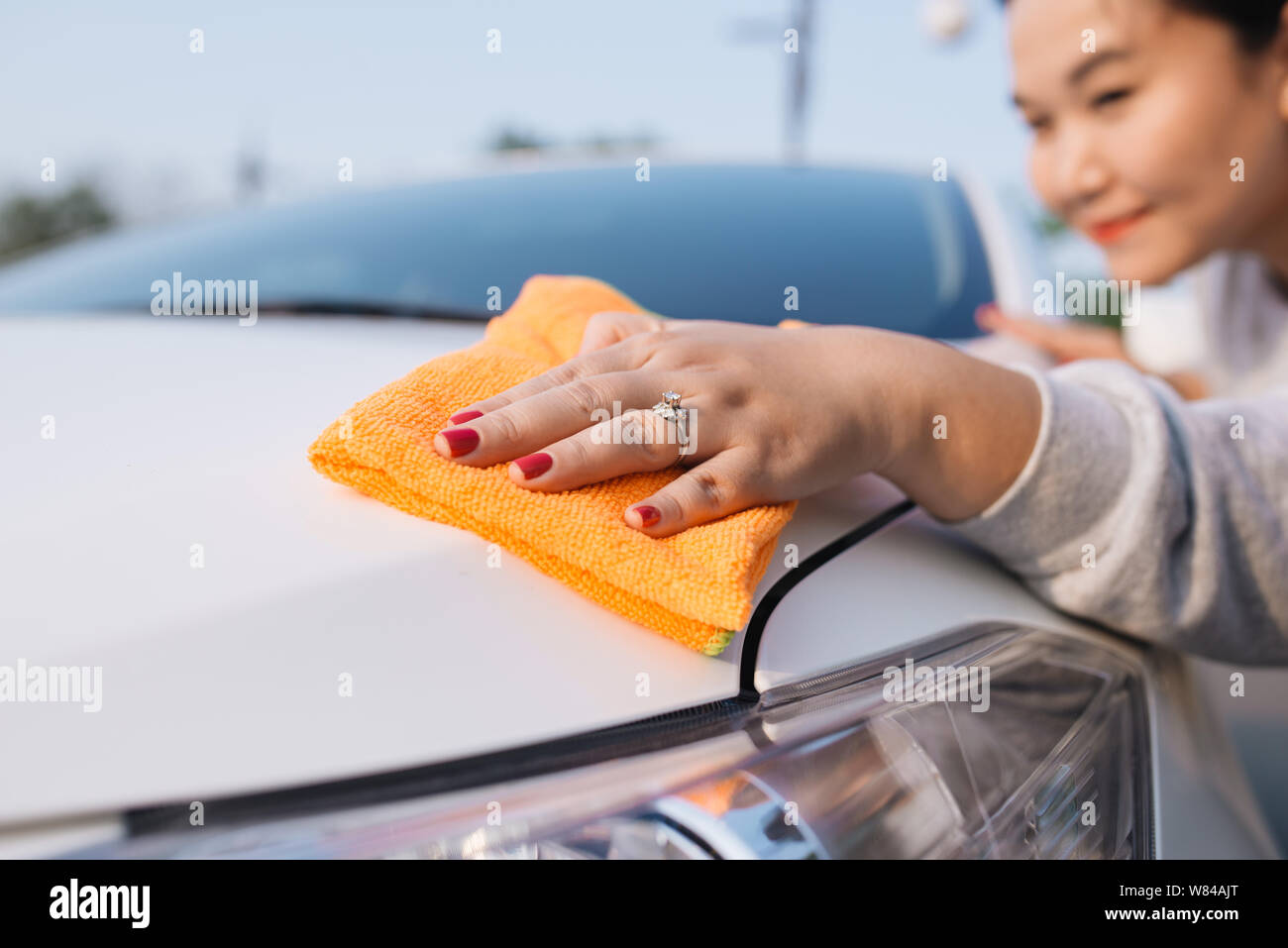 Une femme voiture nettoyage avec chiffon en microfibre, esthétique auto (ou valeting) concept Banque D'Images