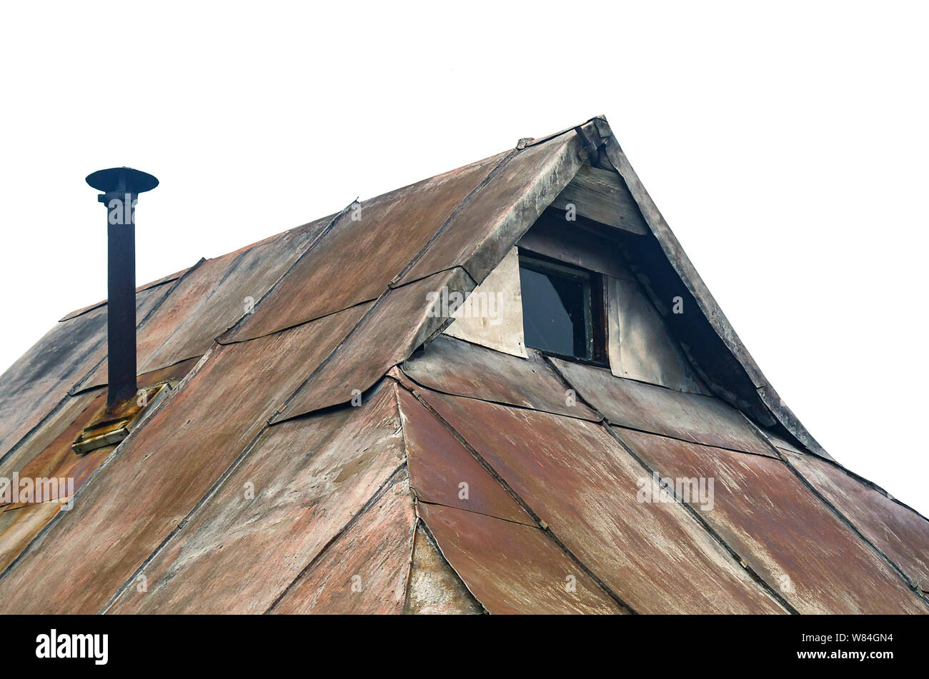 Détails : Chalet de la crête du toit, mur pignon avec petite fenêtre, métal rouillé, feuilles de toit cheminée tuyau métallique avec un capuchon. Concept de style Steampunk. Banque D'Images