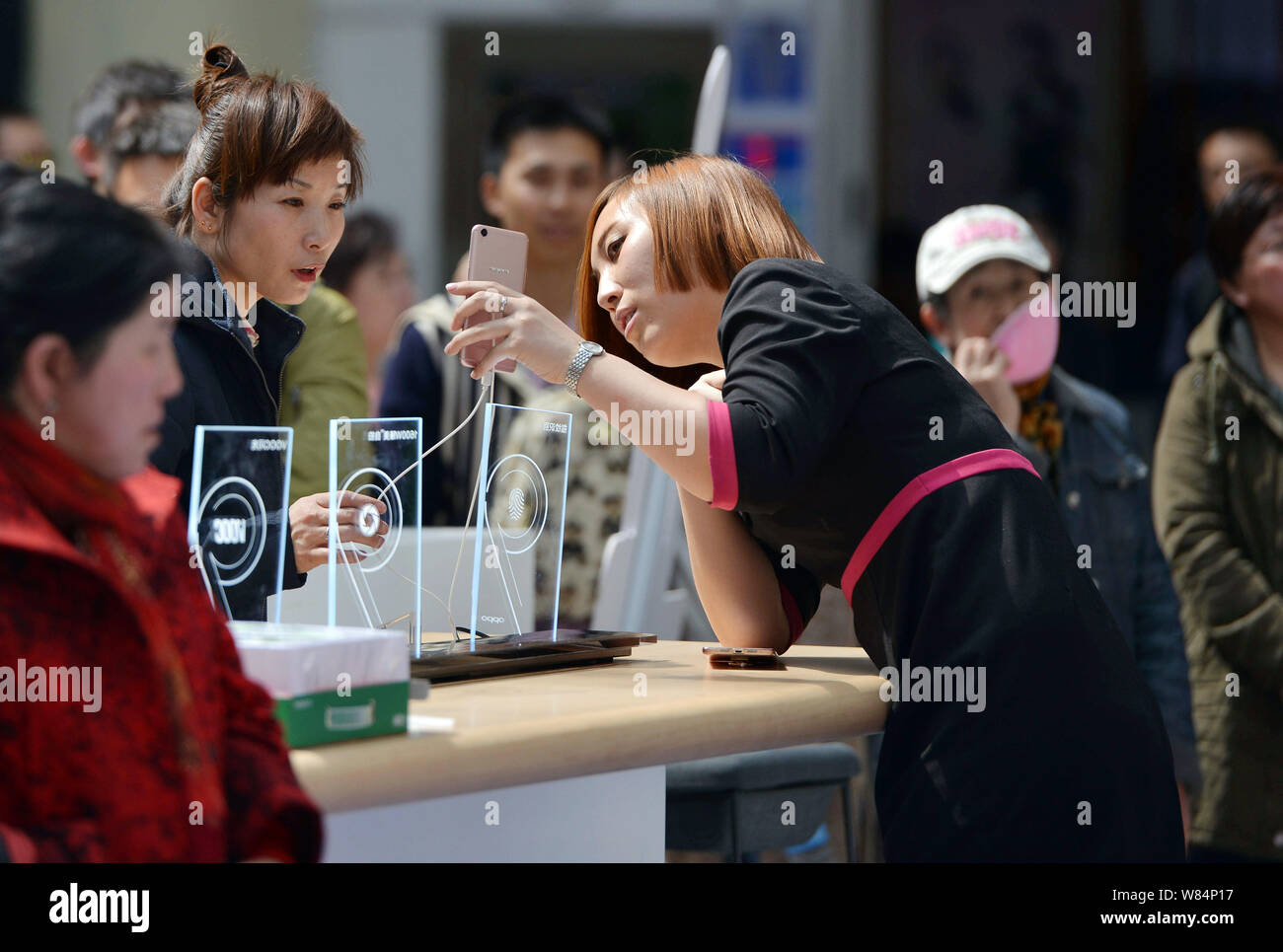 --FILE--une showgirl chinois démontre une oppo smartphone à un visiteur au cours d'une campagne de promotion à Shenyang, ville du nord-est de la Chine Liaoning pro Banque D'Images