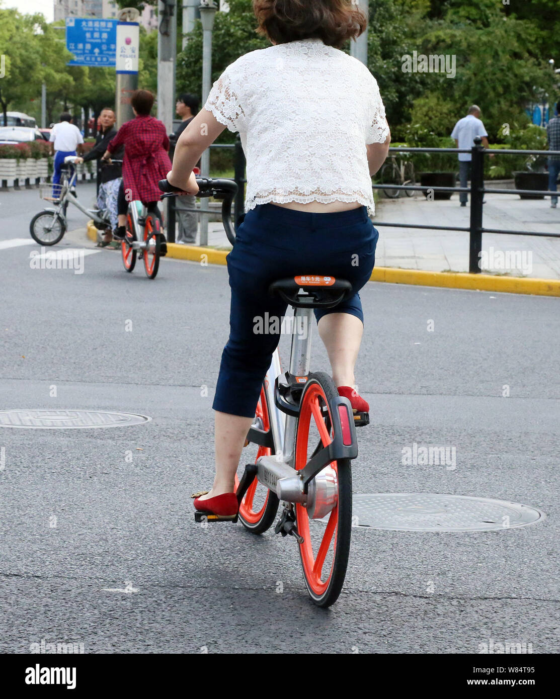 --FILE--cyclistes la bicyclette de vélo libre-service chinois Mobike sur la route de Shanghai, Chine, le 20 septembre 2016. Les deux plus grandes Chine bike-sha Banque D'Images