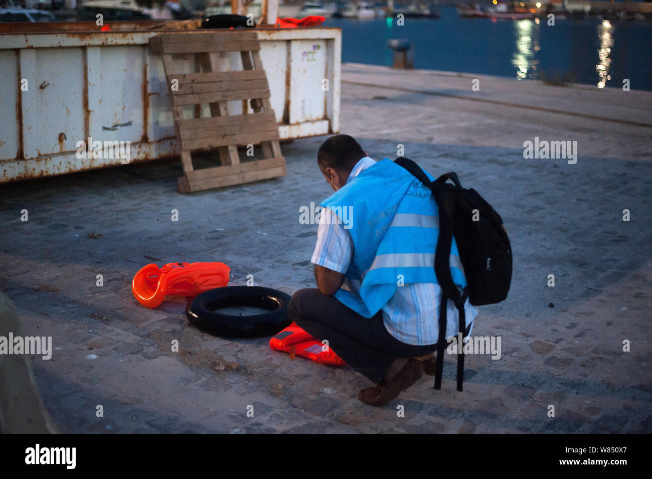 Malaga, Espagne. 07Th Aug 2019. Un membre de la Garde côtière canadienne et européenne des frontières (Frontex) est l'Agence vu l'inspection d'un gilet et d'un flotteur utilisé pour les migrants après leur arrivée au Port de Malaga. Service de Sauvetage Maritime de l'Espagne a sauvé un total de 73 migrants à bord d'un canot traversant la mer d'Alboran et les apporta à Malaga port, où ils étaient assistés par la Croix Rouge Espagnole. Autour de 163 migrants ont été secourus au cours des dernières heures. Credit : SOPA/Alamy Images Limited Live News Banque D'Images