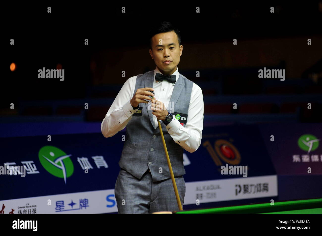 Marco Fu de Hong Kong les craies son cue qu'il estime une tourné contre David Gilbert, de l'Angleterre durant leur premier match de la World Snooker 2016 Banque D'Images