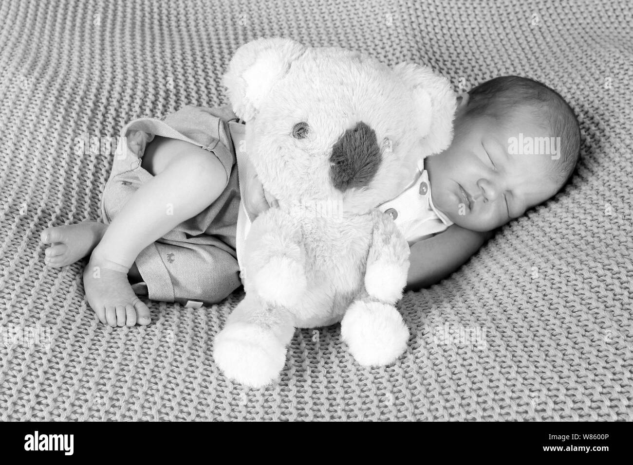 Bébé garçon endormi avec teddy Banque D'Images