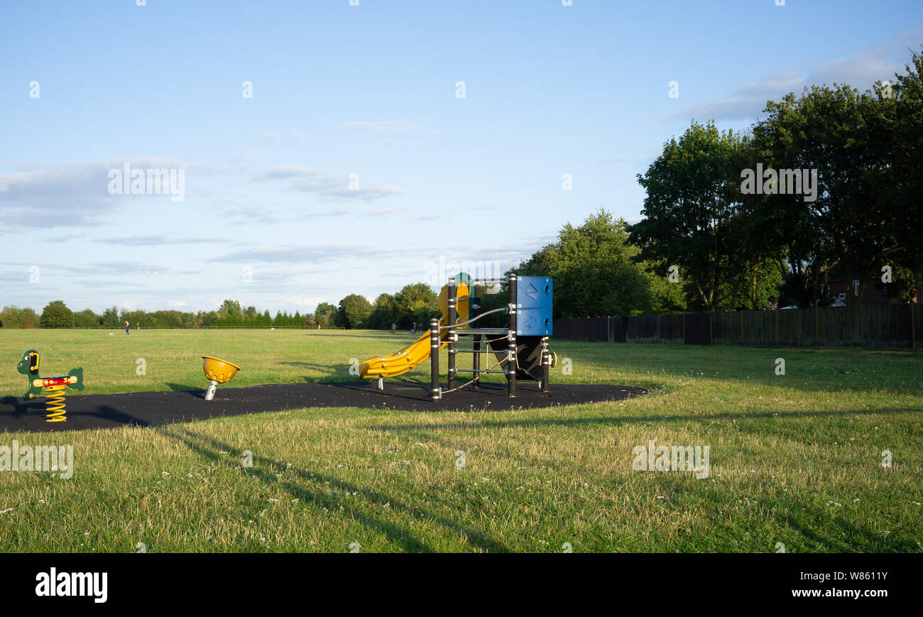 Un terrain de jeux pour enfants, en début de soirée, Caversfield, Oxfordshire Banque D'Images