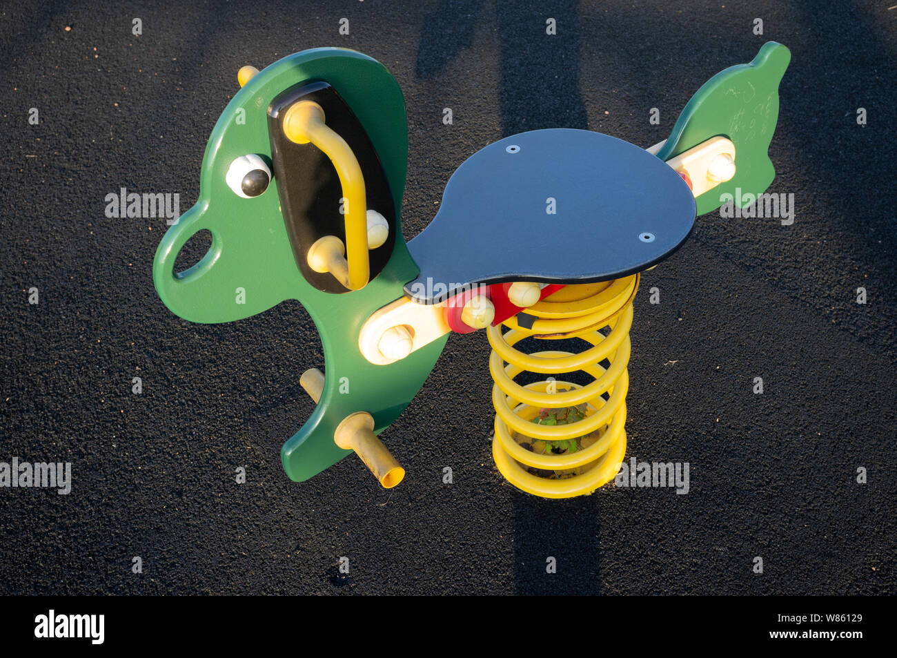 Une aire de jeux pour enfants vide en début de soirée, Caversfield, Oxfordshire. Cheval à bascule. Banque D'Images