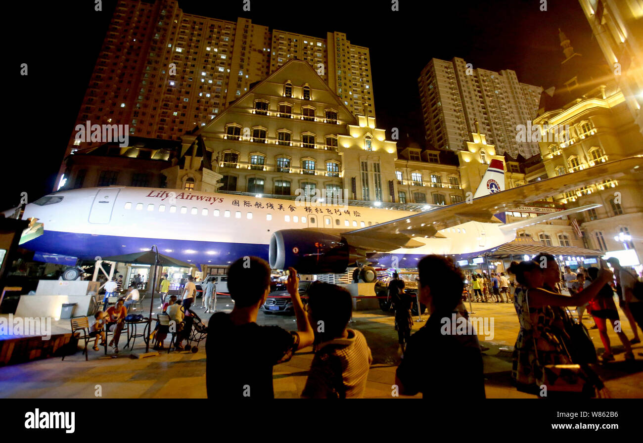 Les résidents locaux chinois regarder les avions Boeing 737-400 restaurant 'Lily Airways' sur l'Optics Valley Rue piétonne dans le centre de Wuhan, Ch Banque D'Images