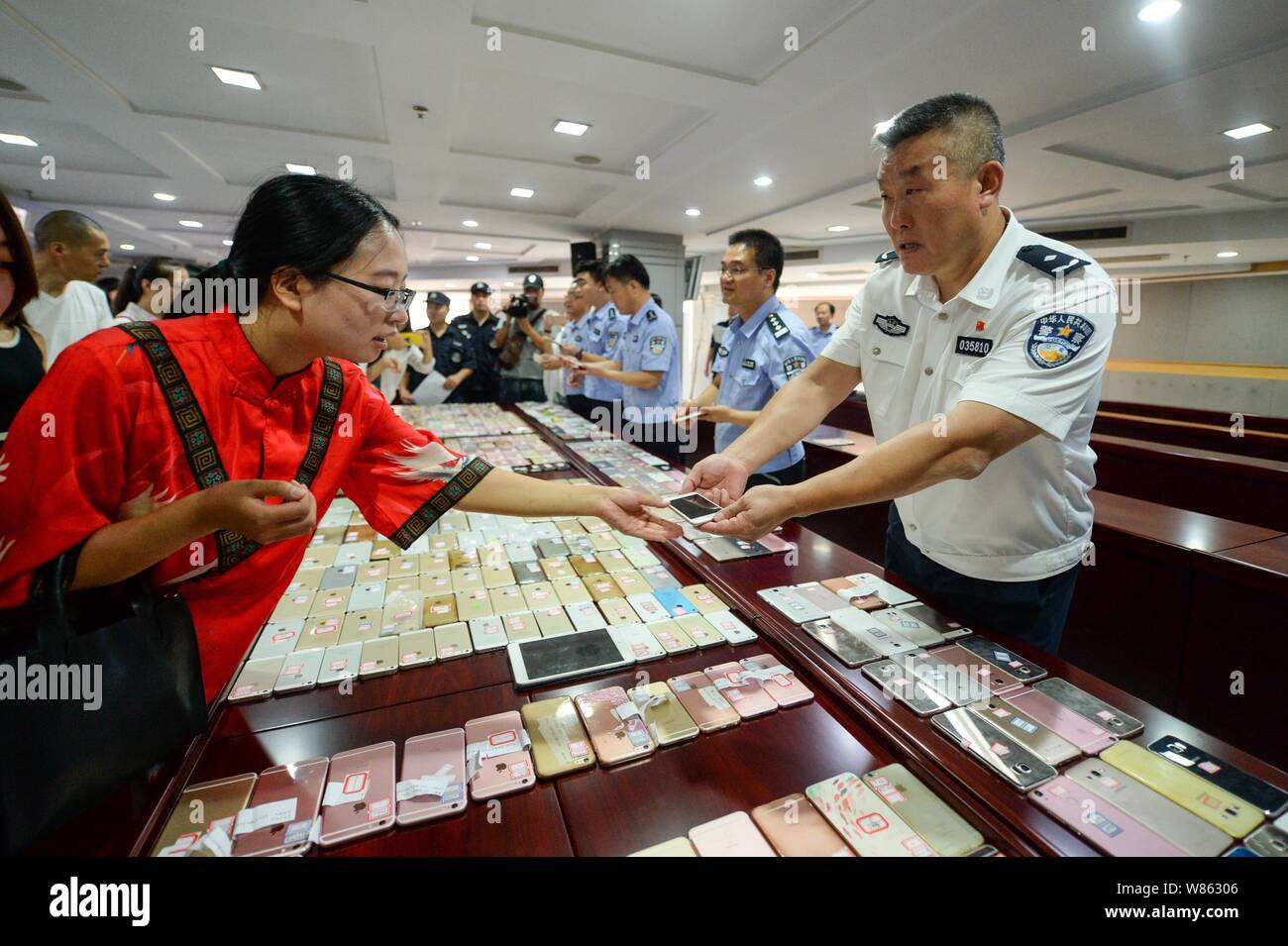 Les agents de police chinois smartphones retour à leurs propriétaires après l'arrestation d'un gang tire à Beijing, Chine, 29 août 2016. Les agents de police r Banque D'Images