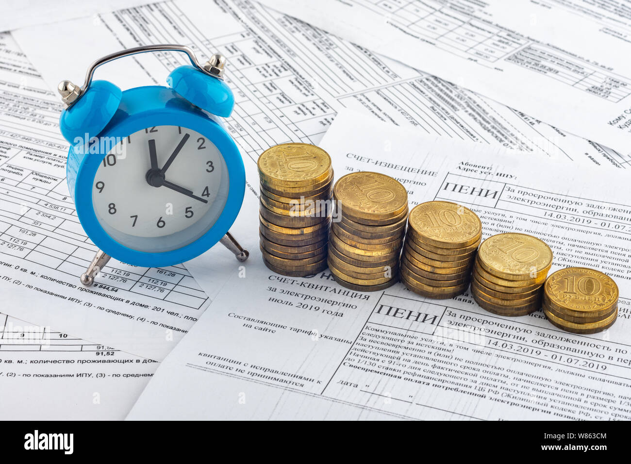 Heures, des piles de pièces de monnaie, reçu avec l'intérêt couru sur le paiement de l'électricité Banque D'Images