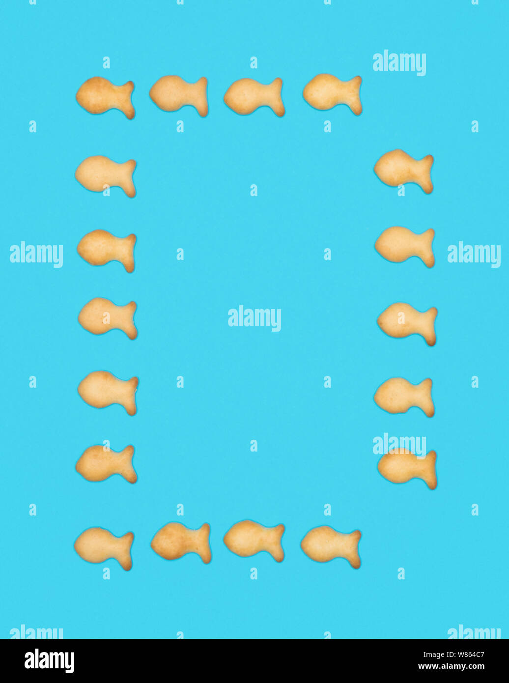 La lettre d'alphabet latin de cookies en forme de poisson sur fond bleu Banque D'Images