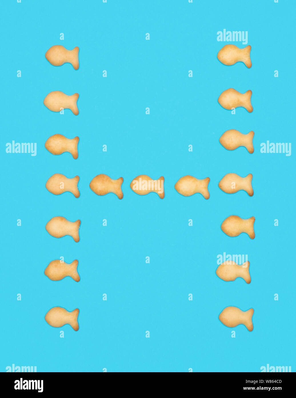 La lettre H alphabet latin de cookies en forme de poisson sur fond bleu Banque D'Images