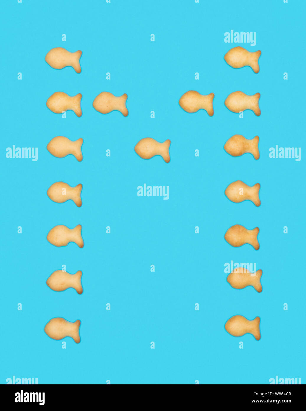La lettre M'alphabet latin de cookies en forme de poisson sur fond bleu Banque D'Images