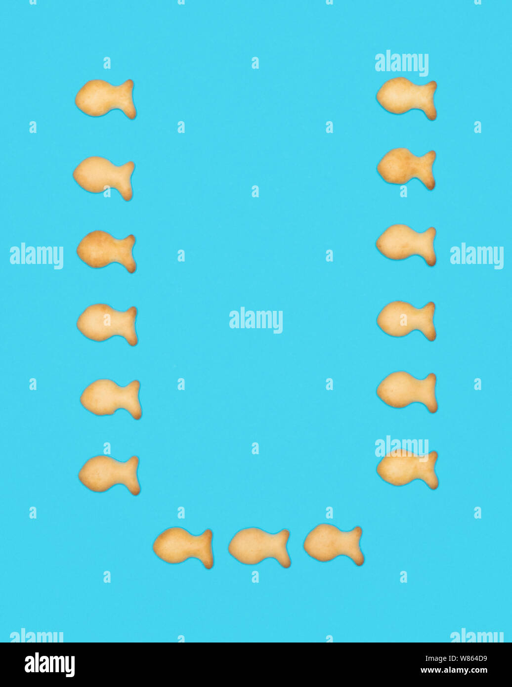 Lettre majuscule latine U alphabet de cookies en forme de poisson sur fond bleu Banque D'Images