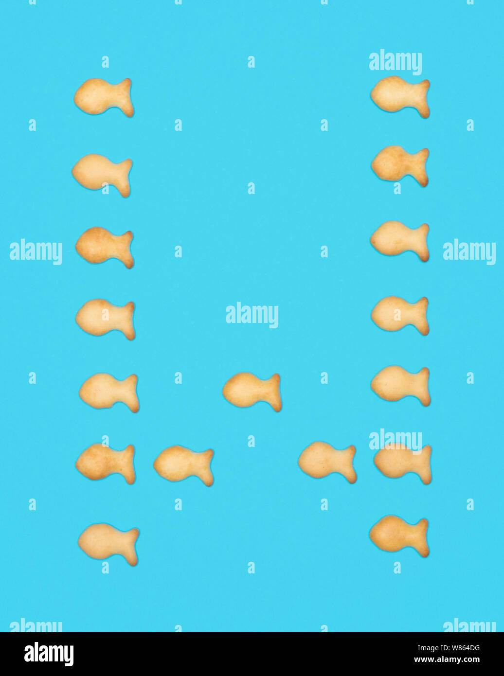 La lettre W alphabet latin de cookies en forme de poisson sur fond bleu Banque D'Images