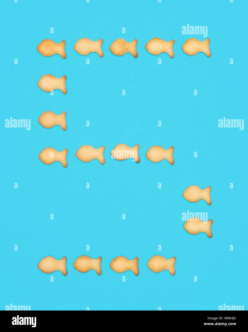 Chiffre 5 Cinq de cookies en forme de poisson sur fond bleu Banque D'Images