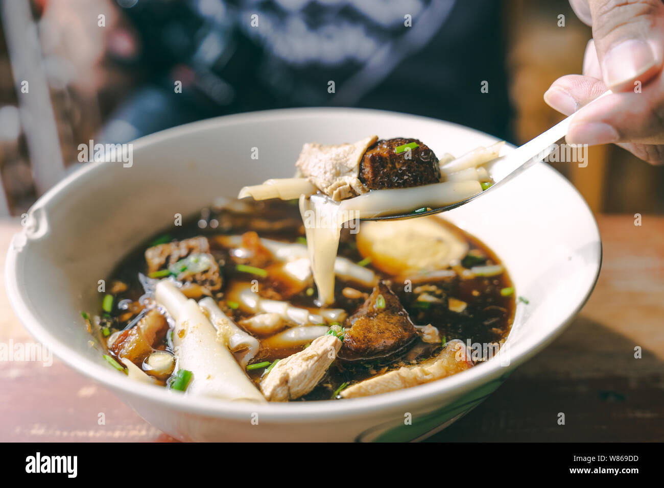 Close up Guay jub, sauce soupe de nouilles thai street food on table en bois avec la main et la fourchette Banque D'Images