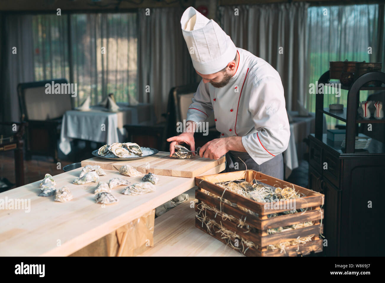 L'ouverture des huîtres creuses et une télévision. Chef ouvre des huîtres au restaurant. Banque D'Images