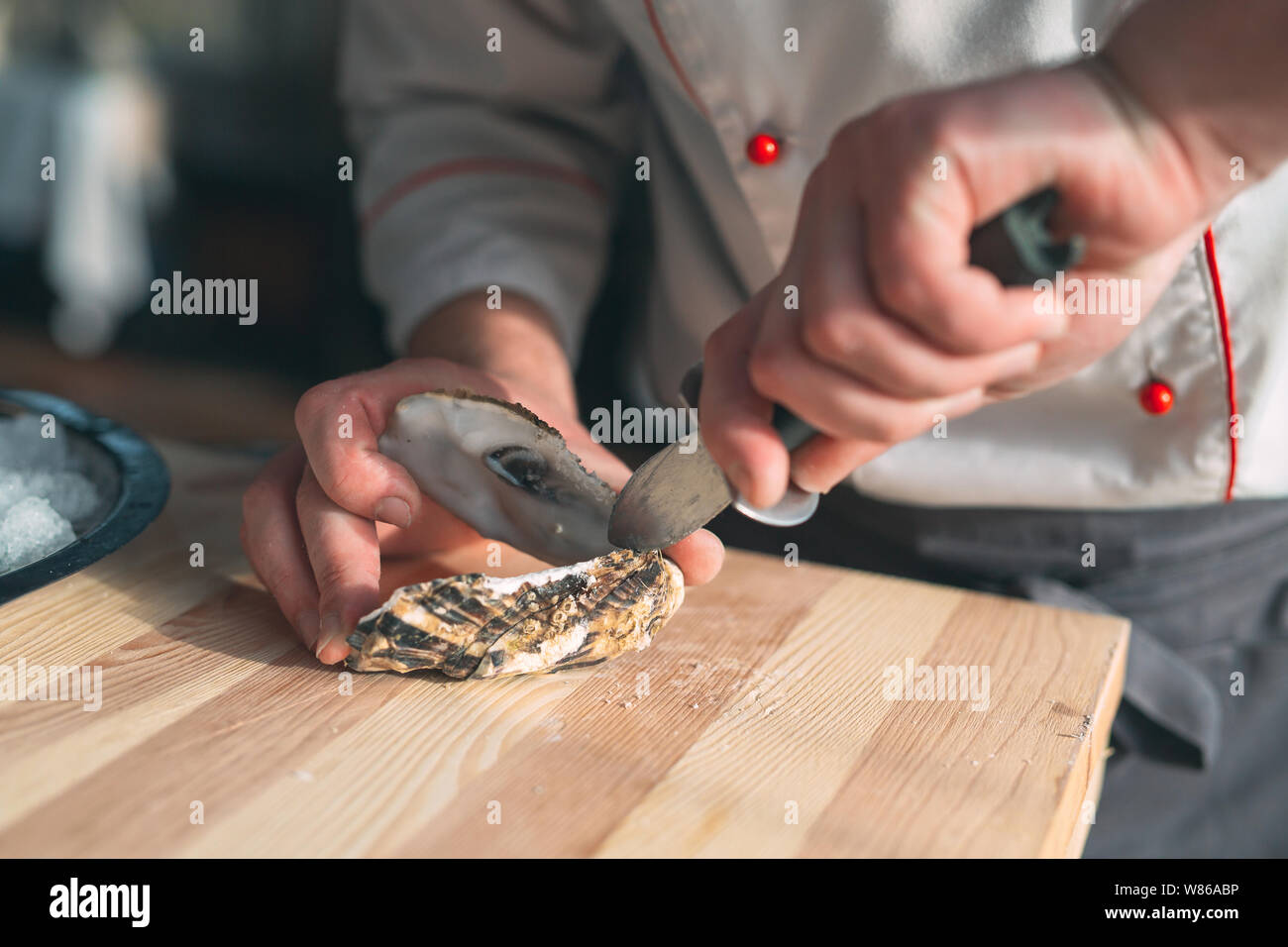 L'ouverture des huîtres creuses et une télévision. Chef ouvre des huîtres au restaurant. Banque D'Images