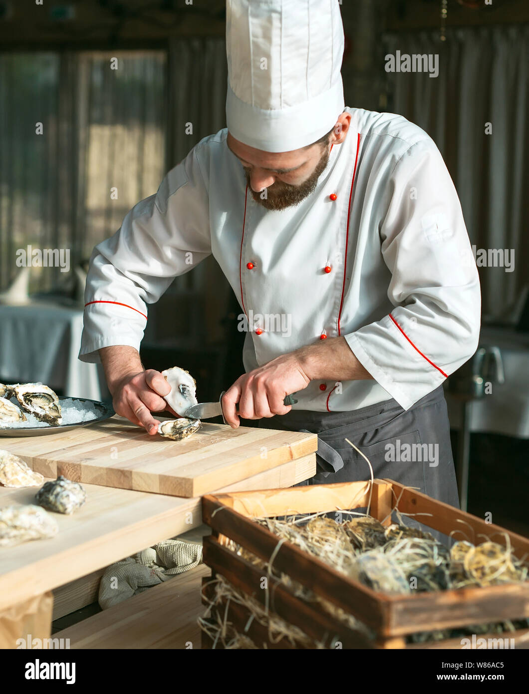 L'ouverture des huîtres creuses et une télévision. Chef ouvre des huîtres au restaurant. Banque D'Images