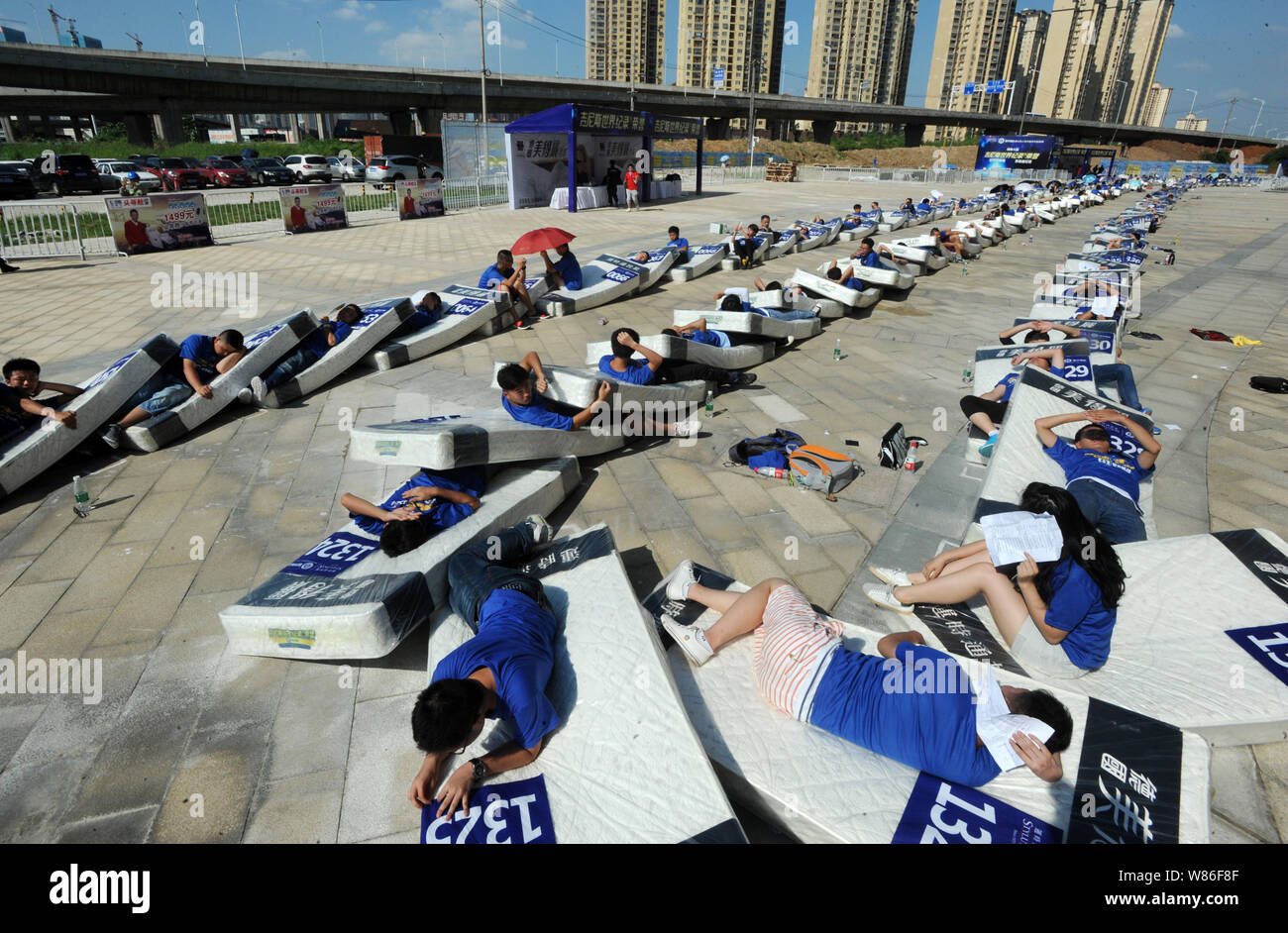 Les participants se trouvent sur leur matelas sous le soleil de plomb après  tumbling sur eux dans une tentative de définition d'un nouveau record  mondial Guinness pour le plus grand h Photo